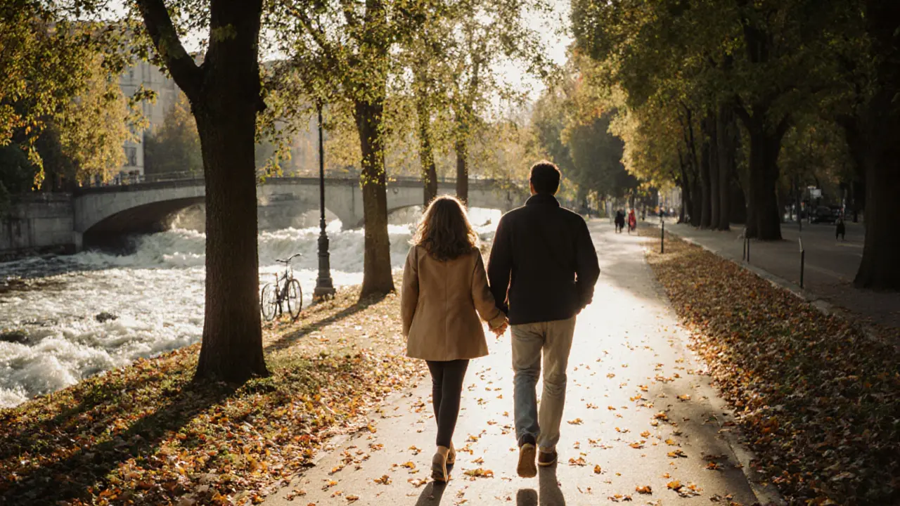 Two people stroll peacefully through Munich&#039;s English Garden in autumn sunlight.