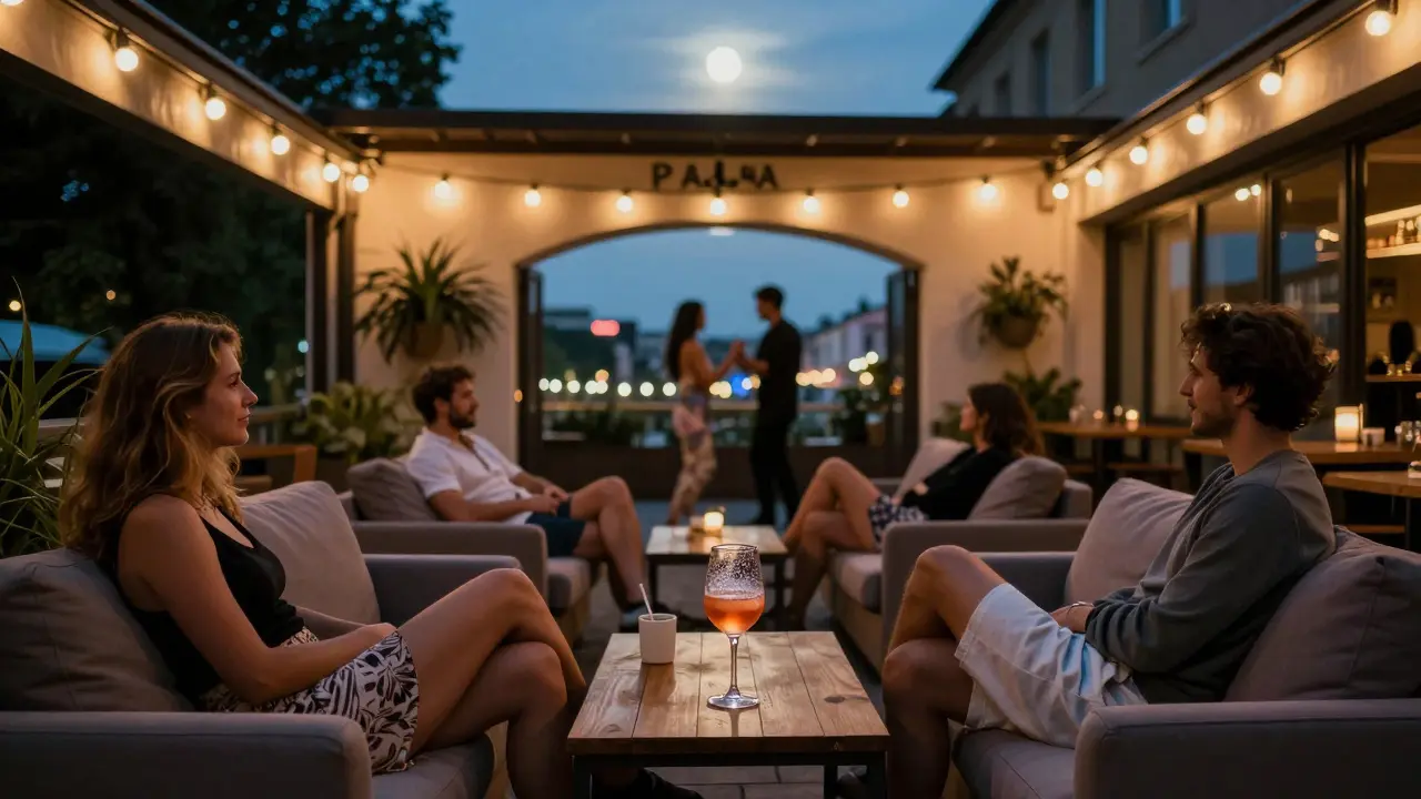 Outdoor terrace at Pacha Munich with couples lounging on sofas under string lights and soft city glow.